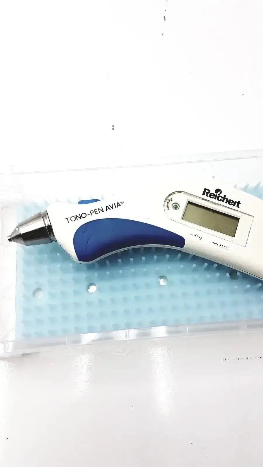 White and blue reichert avia tono-pen tonometer with digital display and textured grip for precise eye pressure measurement