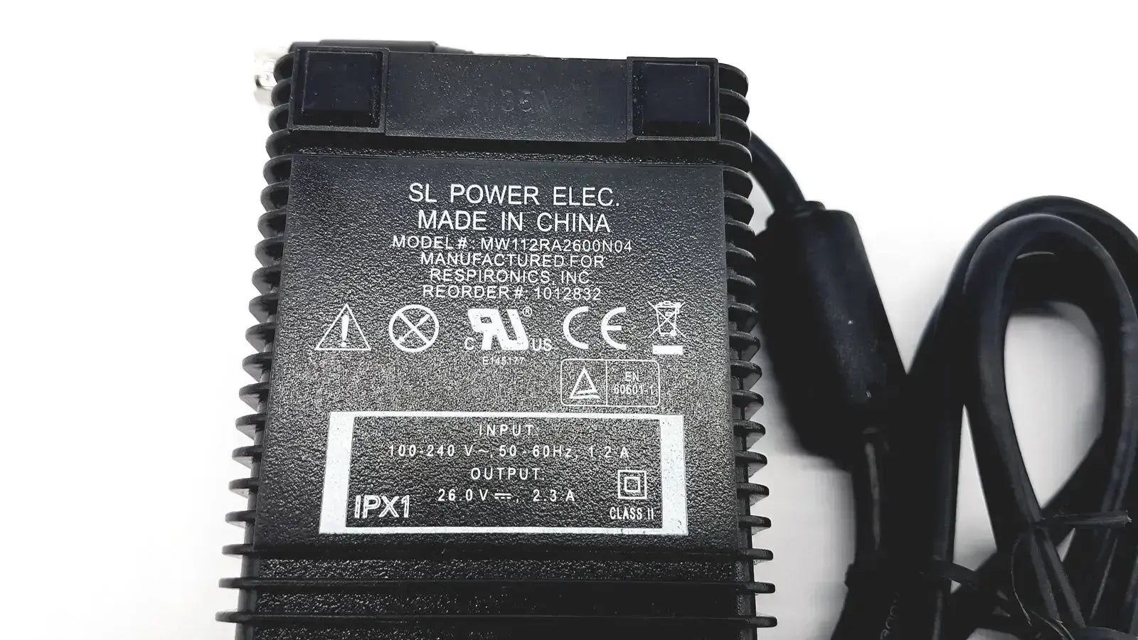 Black plastic respironics power charger with ribbed texture and coiled cable for reliable power supply