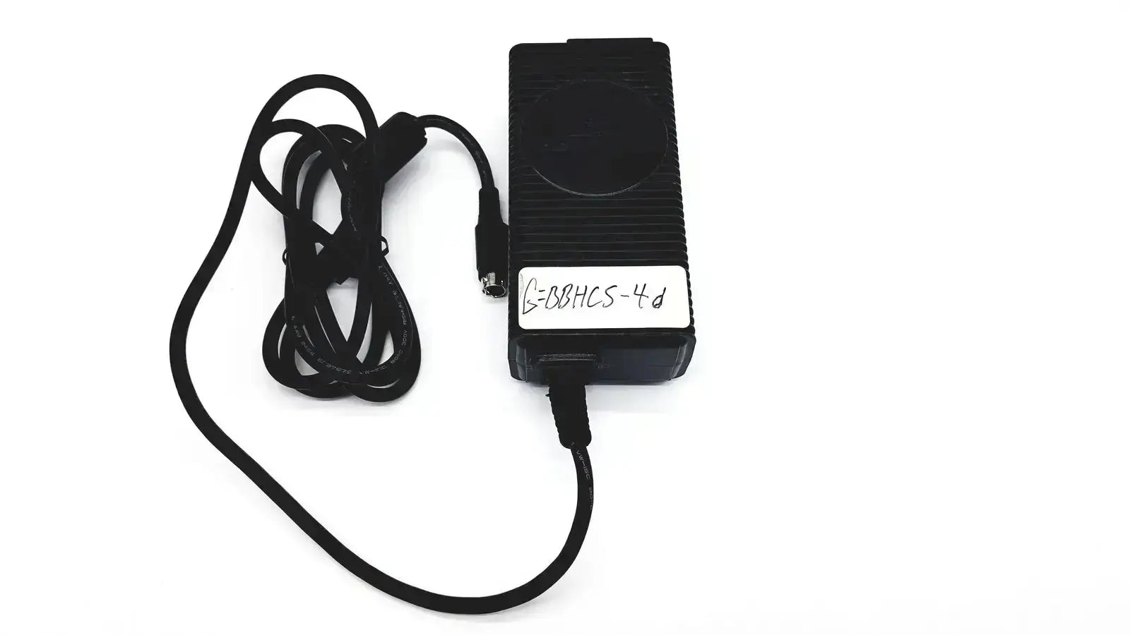 Black rectangular respironics power charger with coiled cable and white label featuring handwritten text