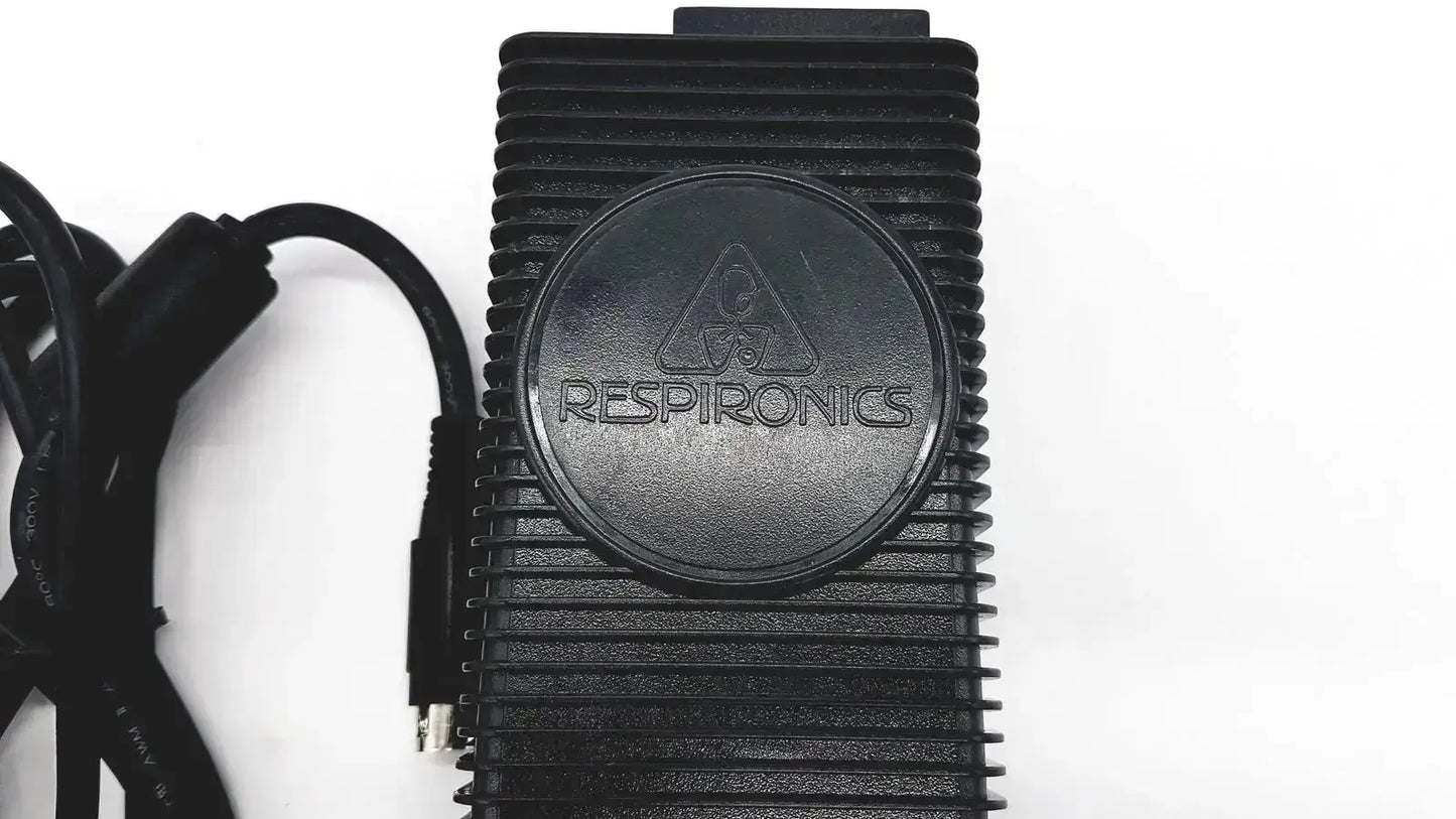 Black rectangular respironics power charger with ribbed texture and circular logo for oxygen concentrator use
