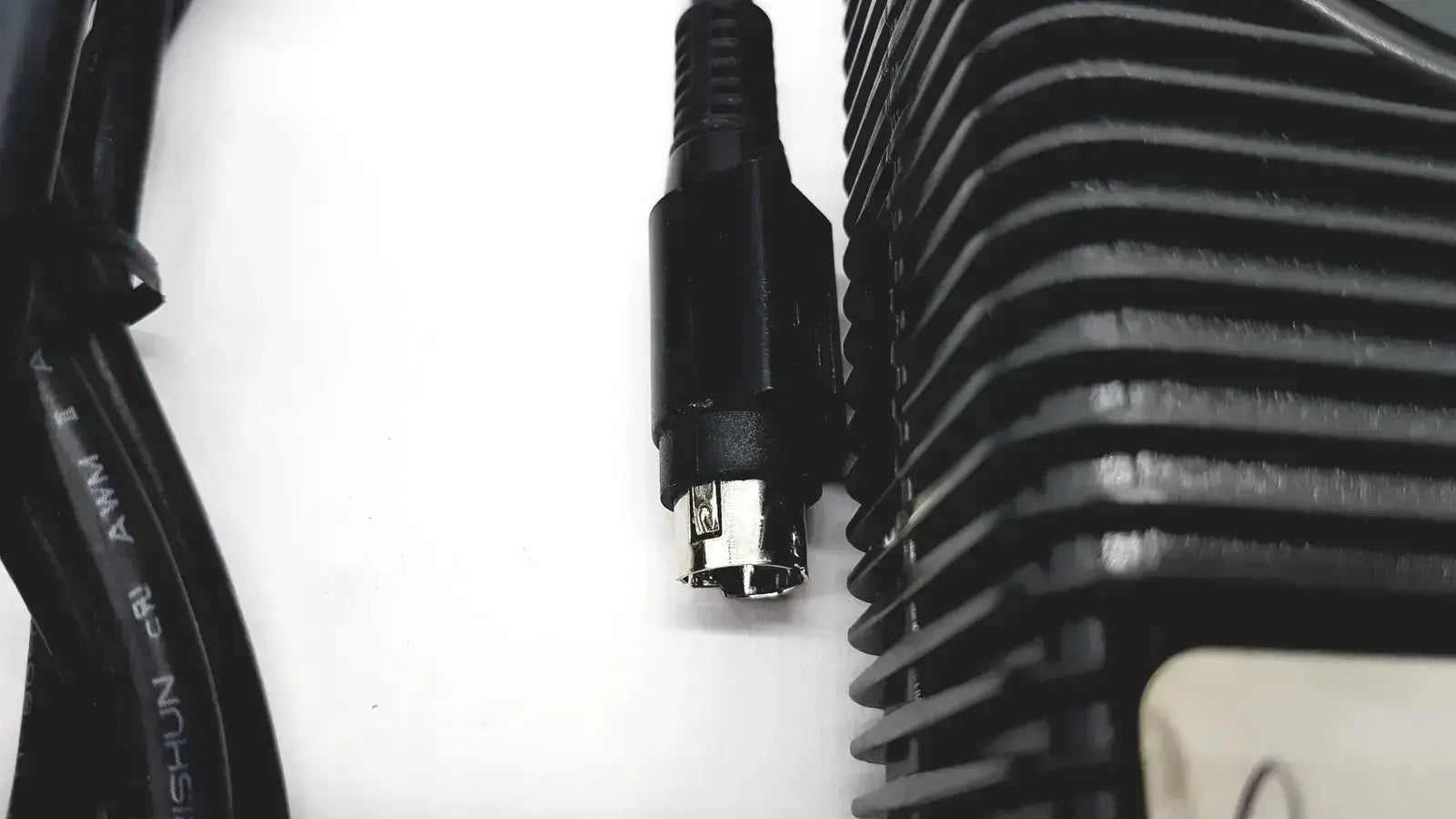 Black ps/2 connector with metallic pins and ribbed plastic housing for respironics power charger with cable