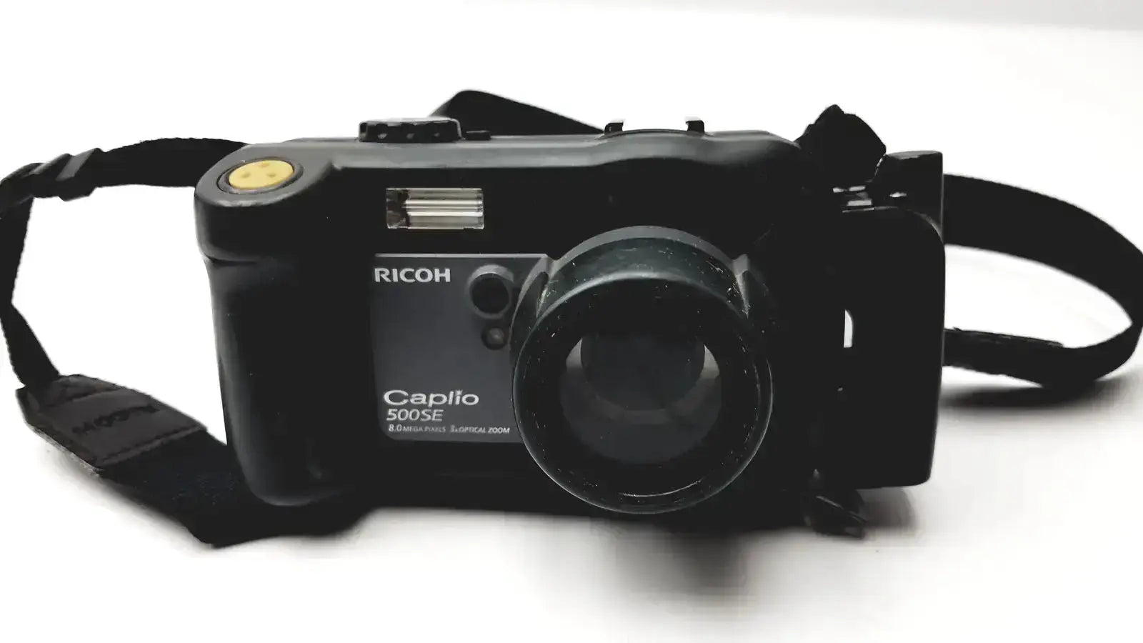 Black Ricoh Caplio 500SE digital camera with 8.0 mega pixels and yellow shutter button featuring 3x optical zoom digital lens