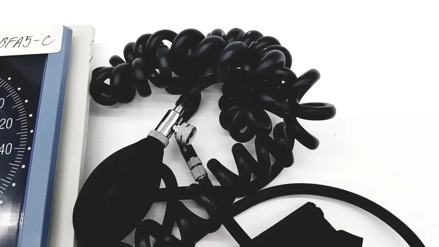 Black coiled rubber tubing with metallic connectors and bulbous inflation chamber of riester big ben square sphygmomanometer