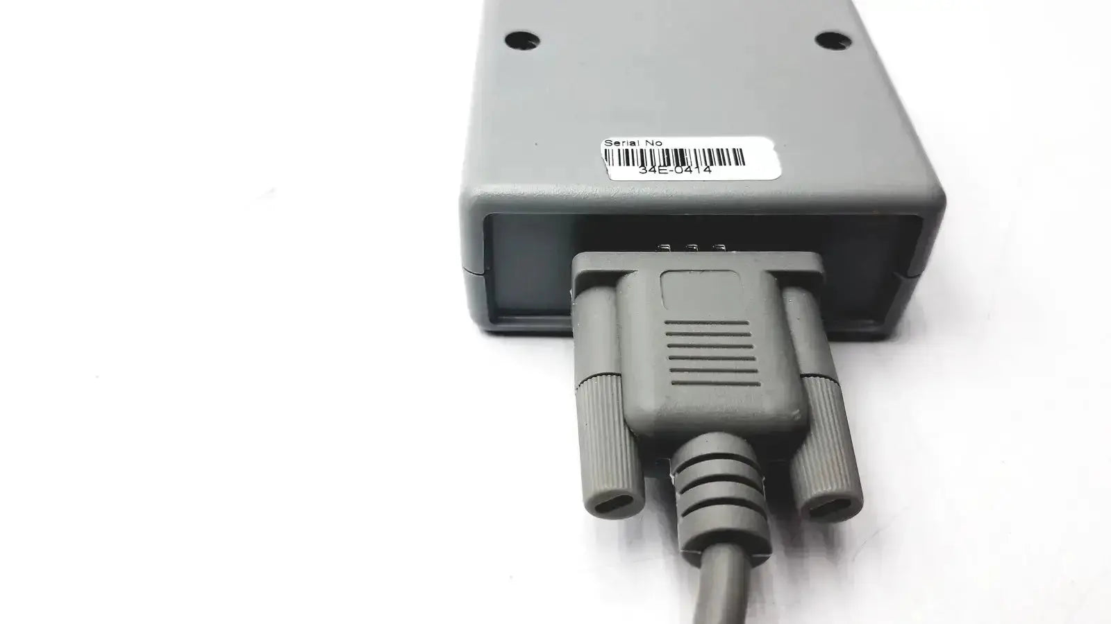 Gray plastic d-sub adapter nellcor oximax plugged into a rigel medical rectangular device with mounting holes and barcode label
