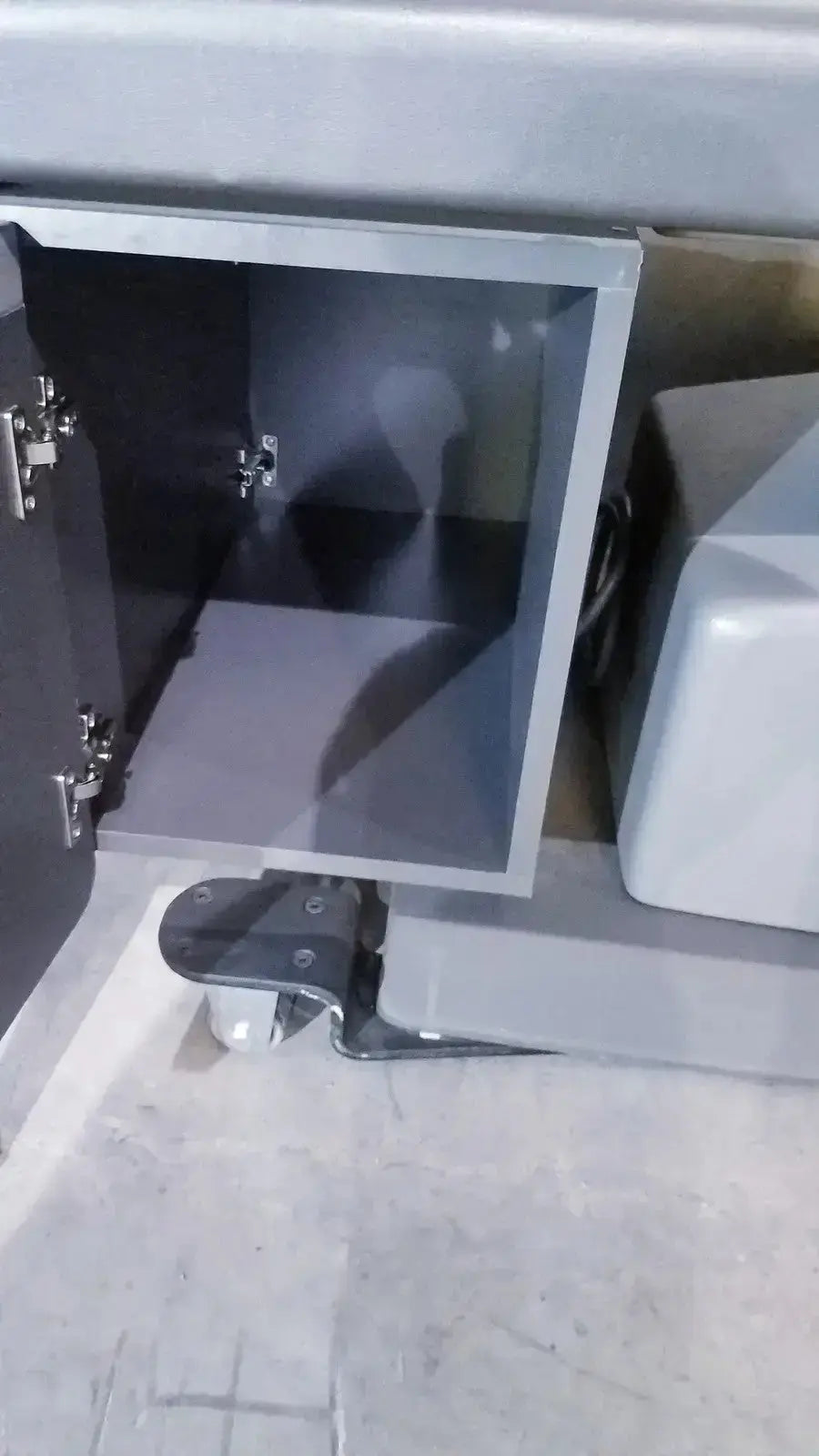 Gray metal cabinet with glass door and hinges shown with ritter 106 exam table featuring up and down foot paddle hospital surplus