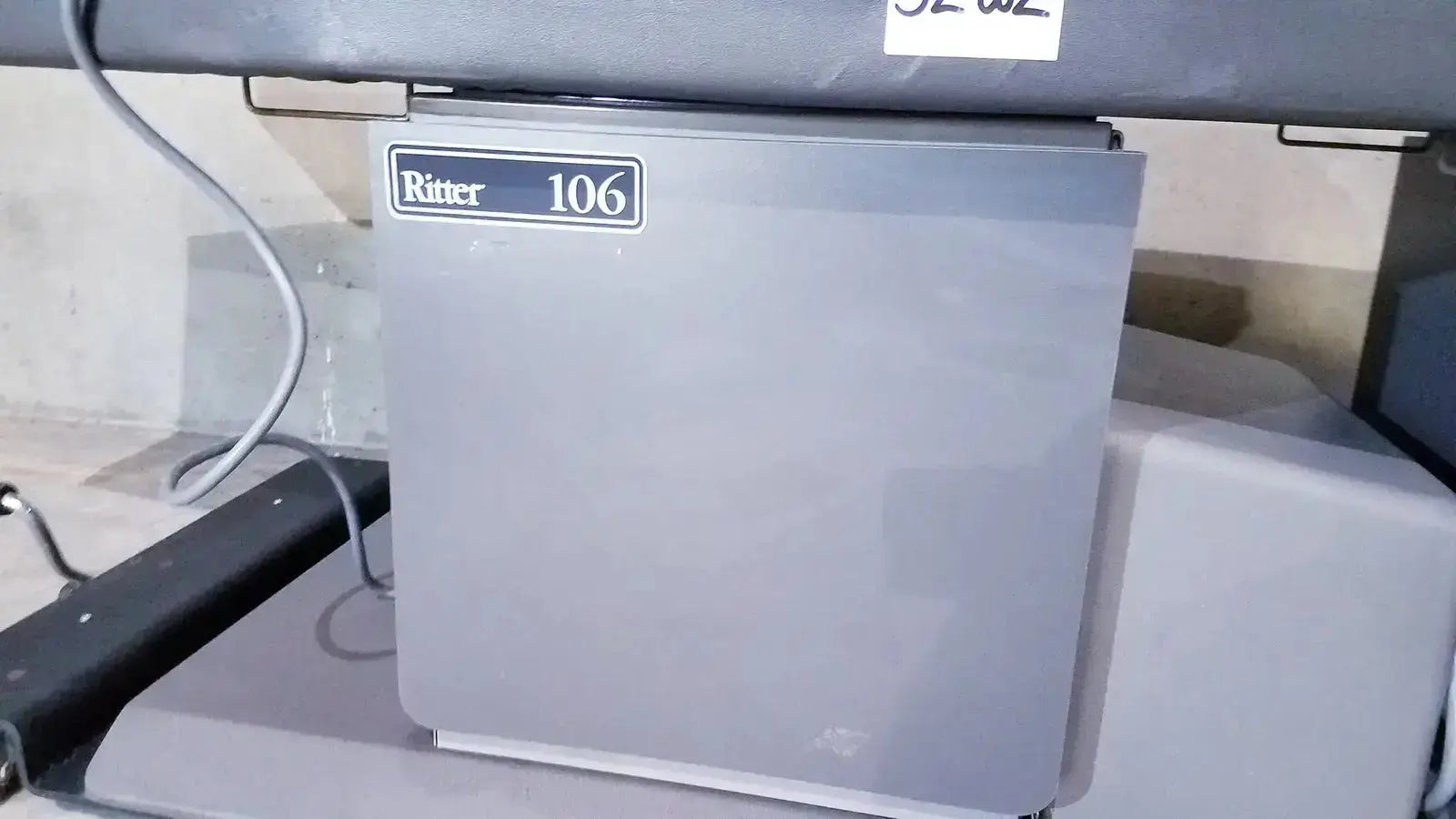 Gray ritter 106 ice machine with metallic finish shown alongside ritter 106 exam table with up and down foot paddle for hospital surplus use