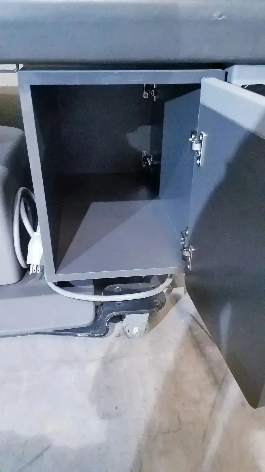 Gray metal hospital surplus cabinet with hinged doors on ritter 106 exam table featuring up and down foot paddle