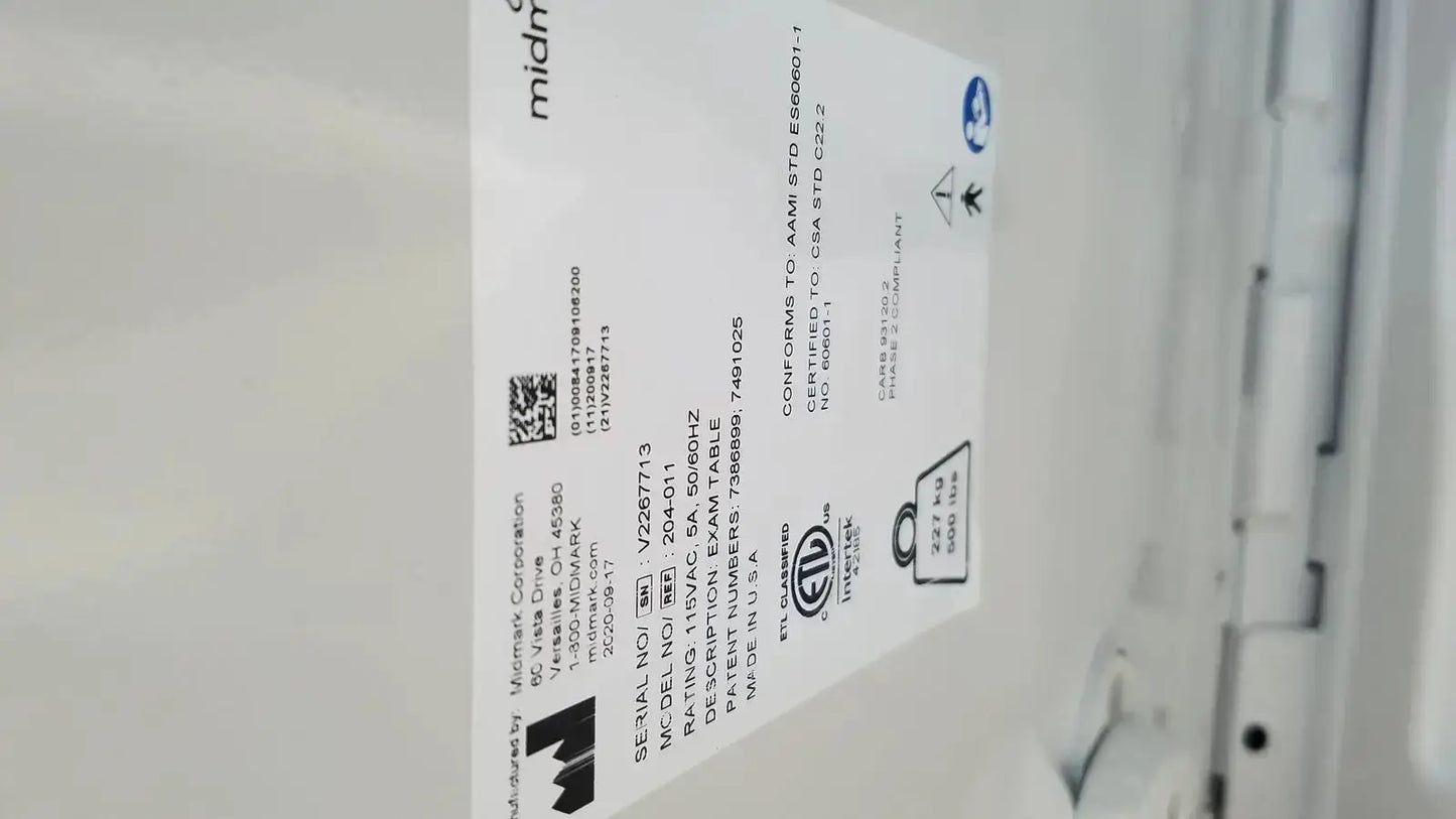 White rectangular label with black text on the back of ritter by midmark exam table model 204-011 used medical equipment for sale