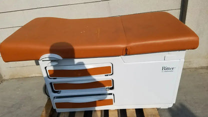 White ritter medical exam table model 204-011 with tan padded surface and matching drawer fronts for used medical equipment sale