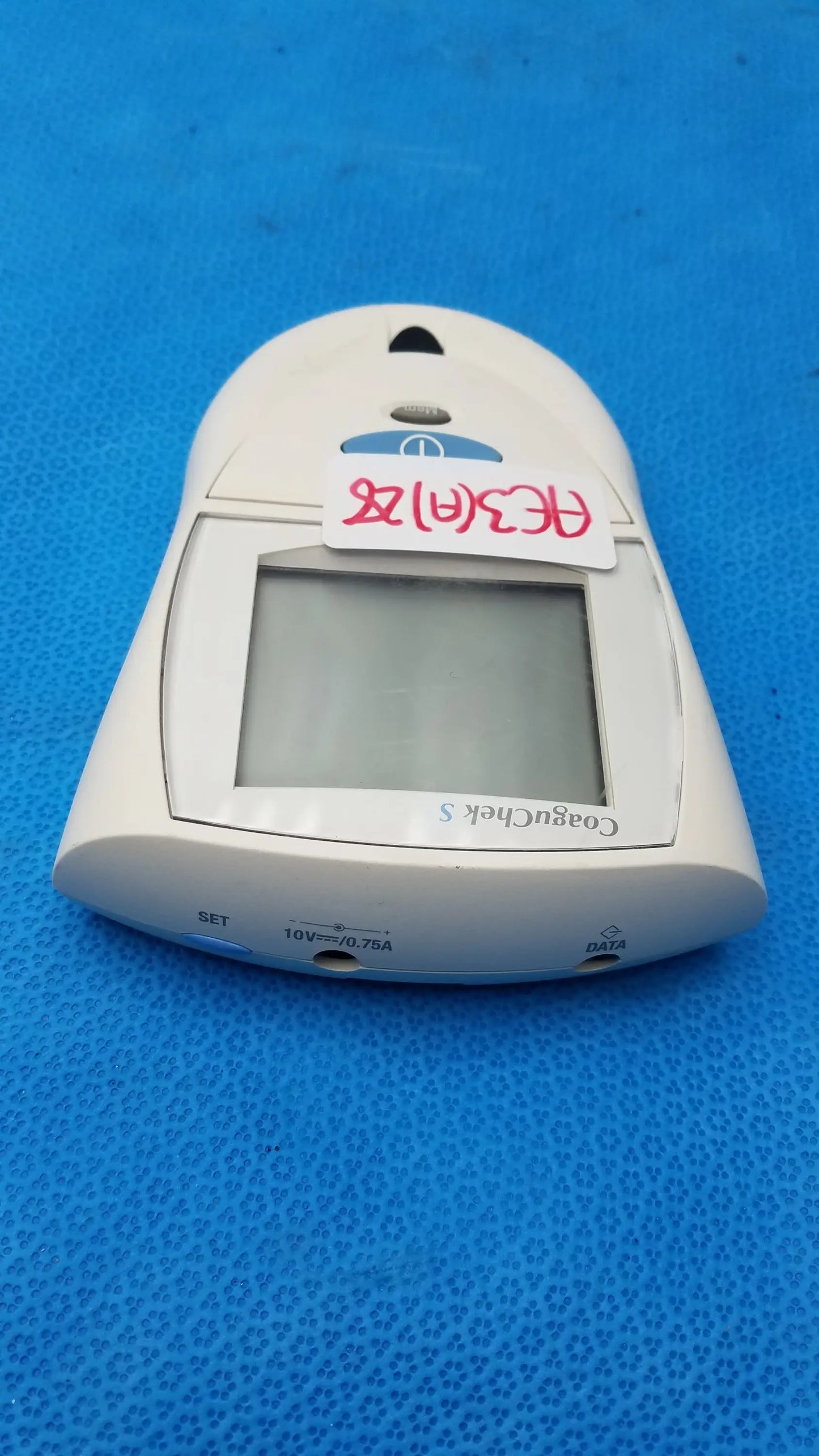 White plastic Roche CoaguChek S coagulation meter with rectangular screen and labeled ports for medical equipment use