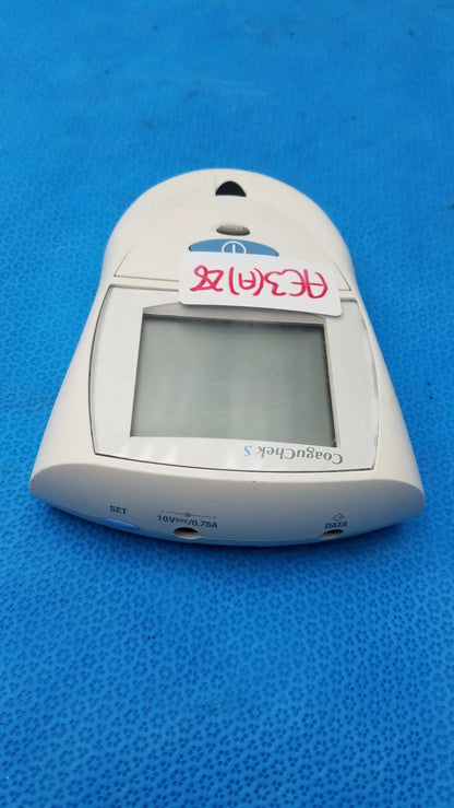 White plastic Roche CoaguChek S coagulation meter with rectangular screen and labeled ports for medical equipment use