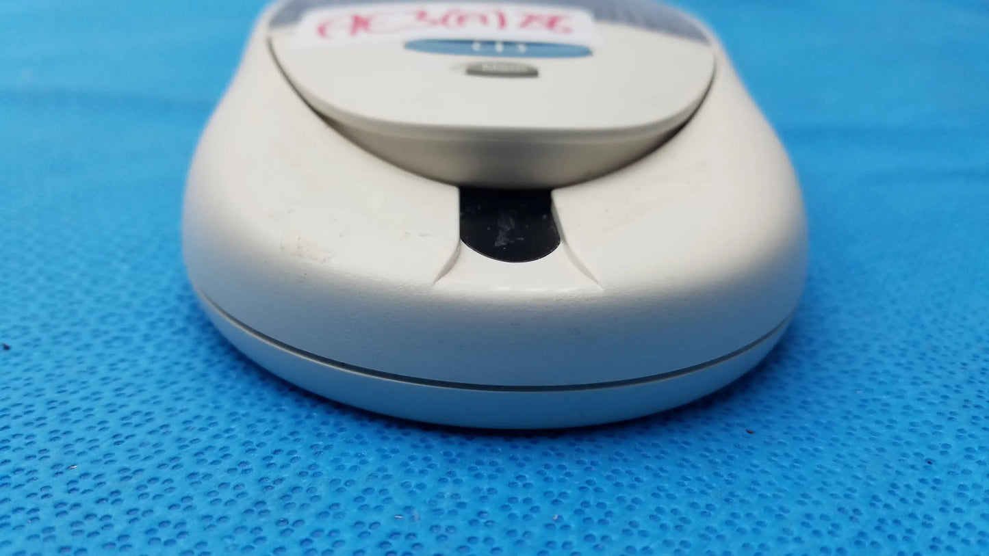 White plastic computer mouse with silver scroll wheel and blue logo for Roche CoaguChek S coagulation meter medical equipment