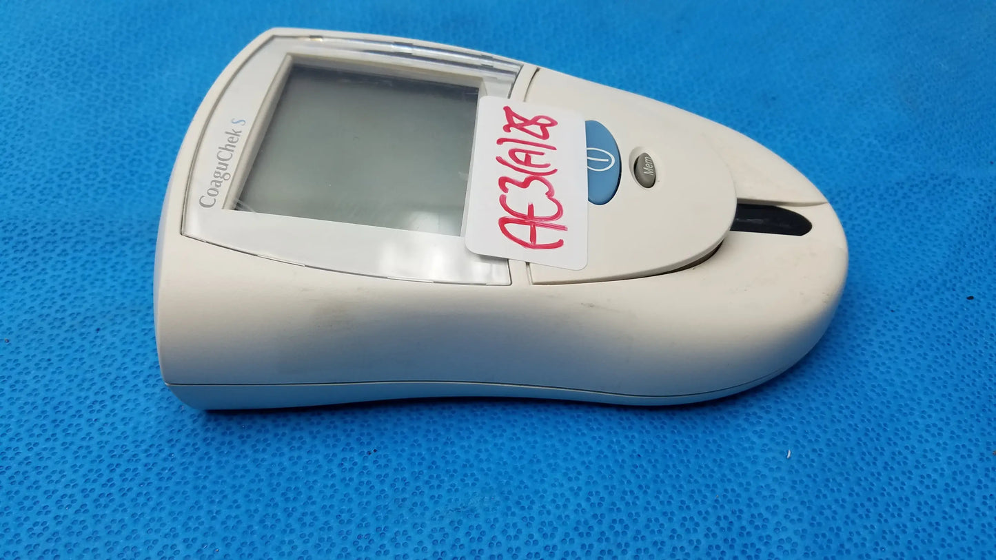 White plastic Roche CoaguChek S coagulation meter with small screen and blue button used in reuse medical equipment