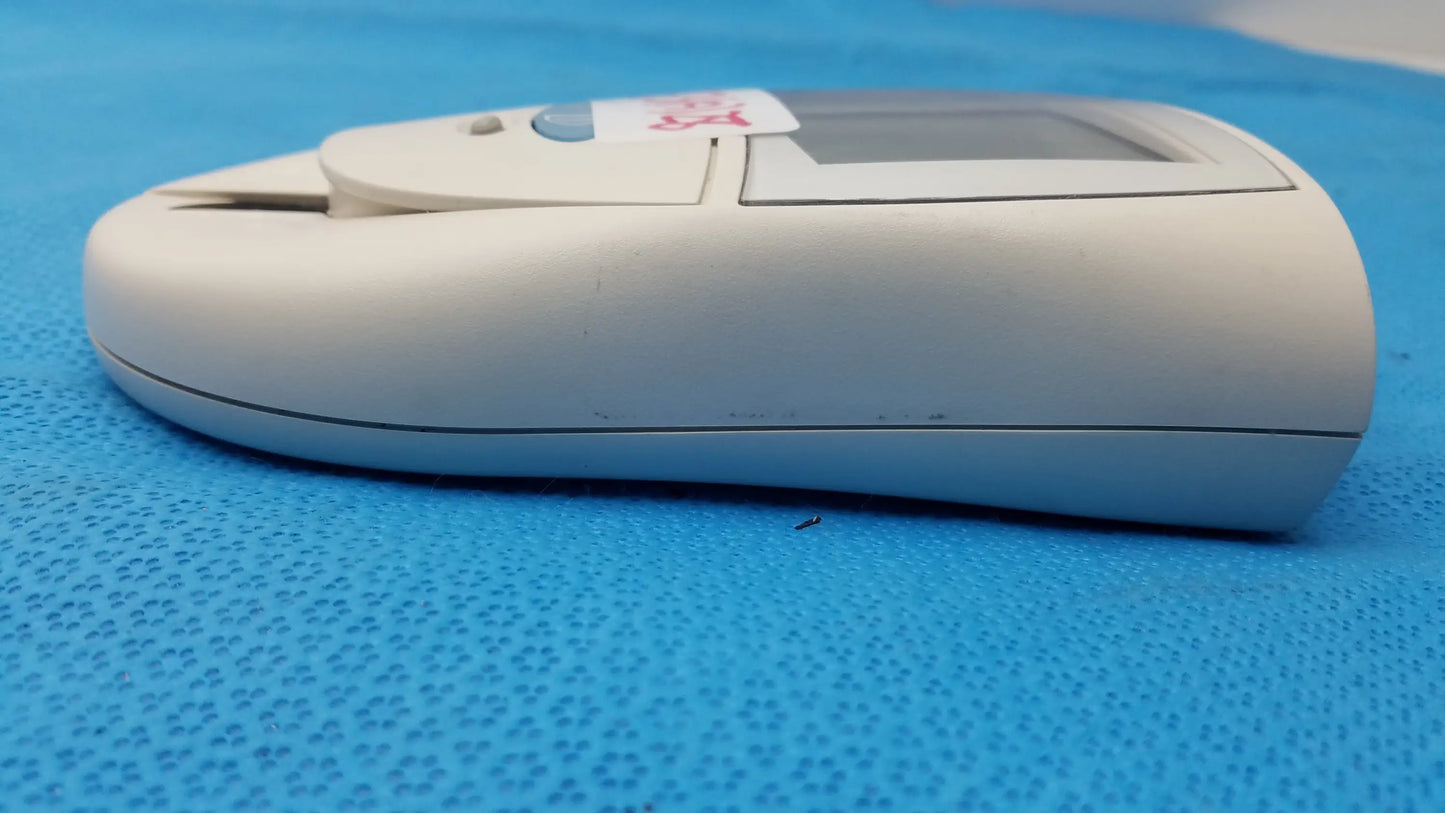 White plastic Roche CoaguChek S coagulation meter with small screen and test strip slot for reuse medical equipment use