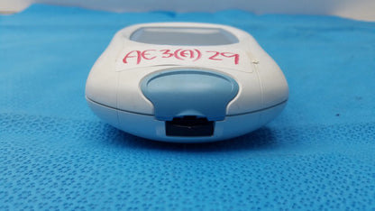 White and light blue plastic roche coaguchek xs plus coagulation meter with small rectangular screen marked in red ink medical equipment