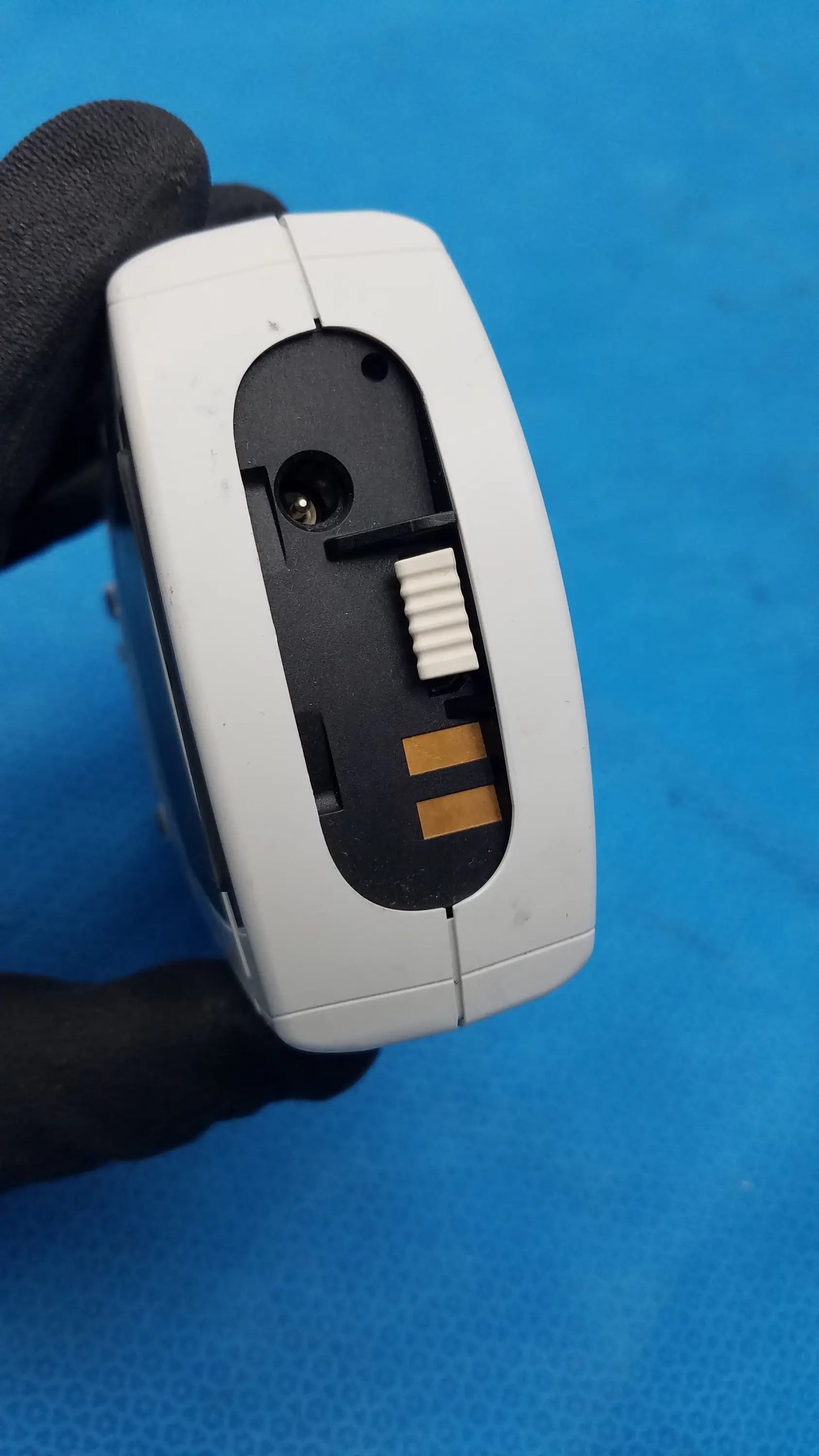 White plastic handheld barcode scanner with black interior, gold contacts, and white buttons for Roche CoaguChek coagulation meter medical equipment