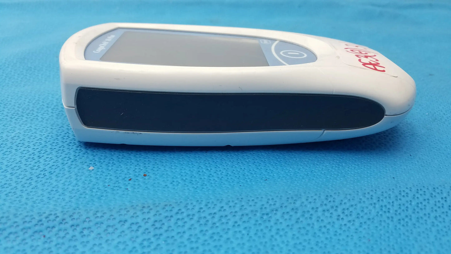 White plastic roche coaguchek xs plus coagulation meter with gray screen and red branding medical equipment