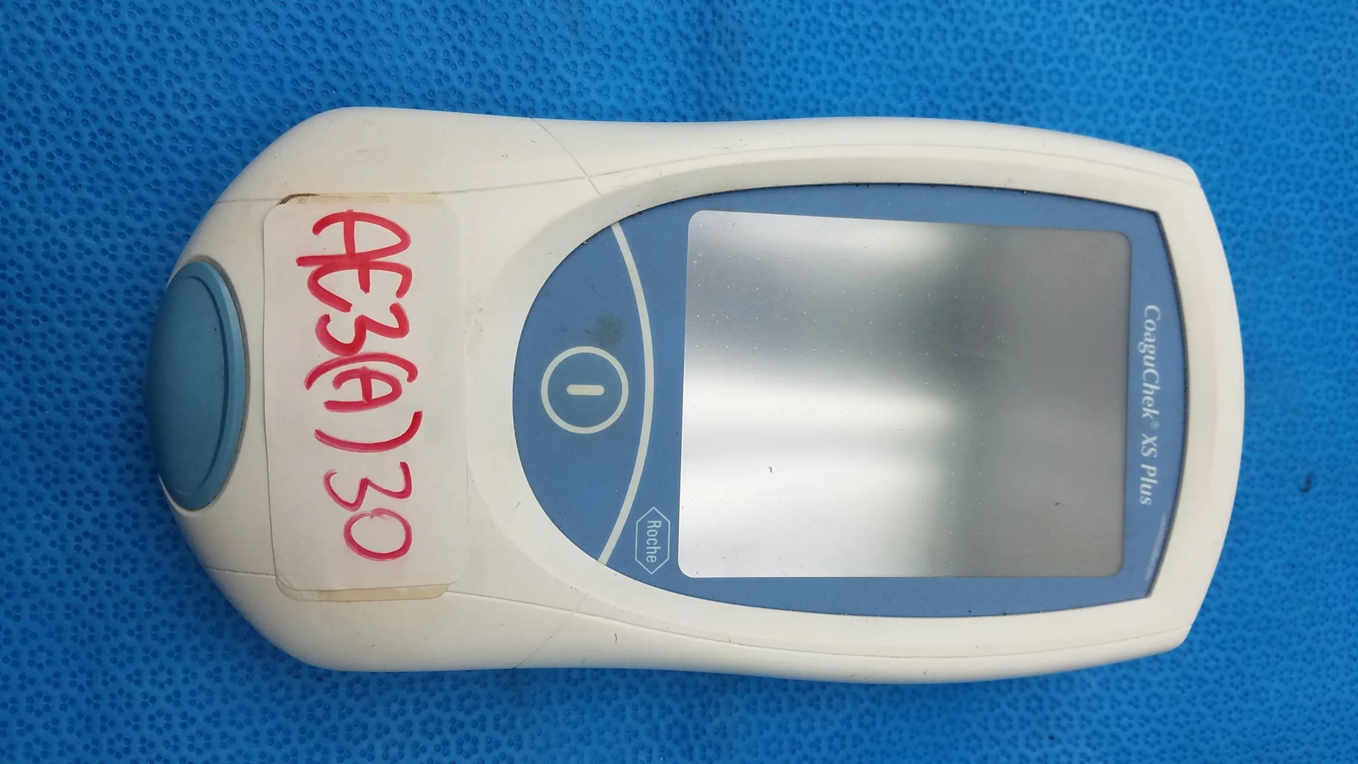 White and blue roche coaguchek xs plus coagulation meter medical equipment with digital screen by bruel & kjaer