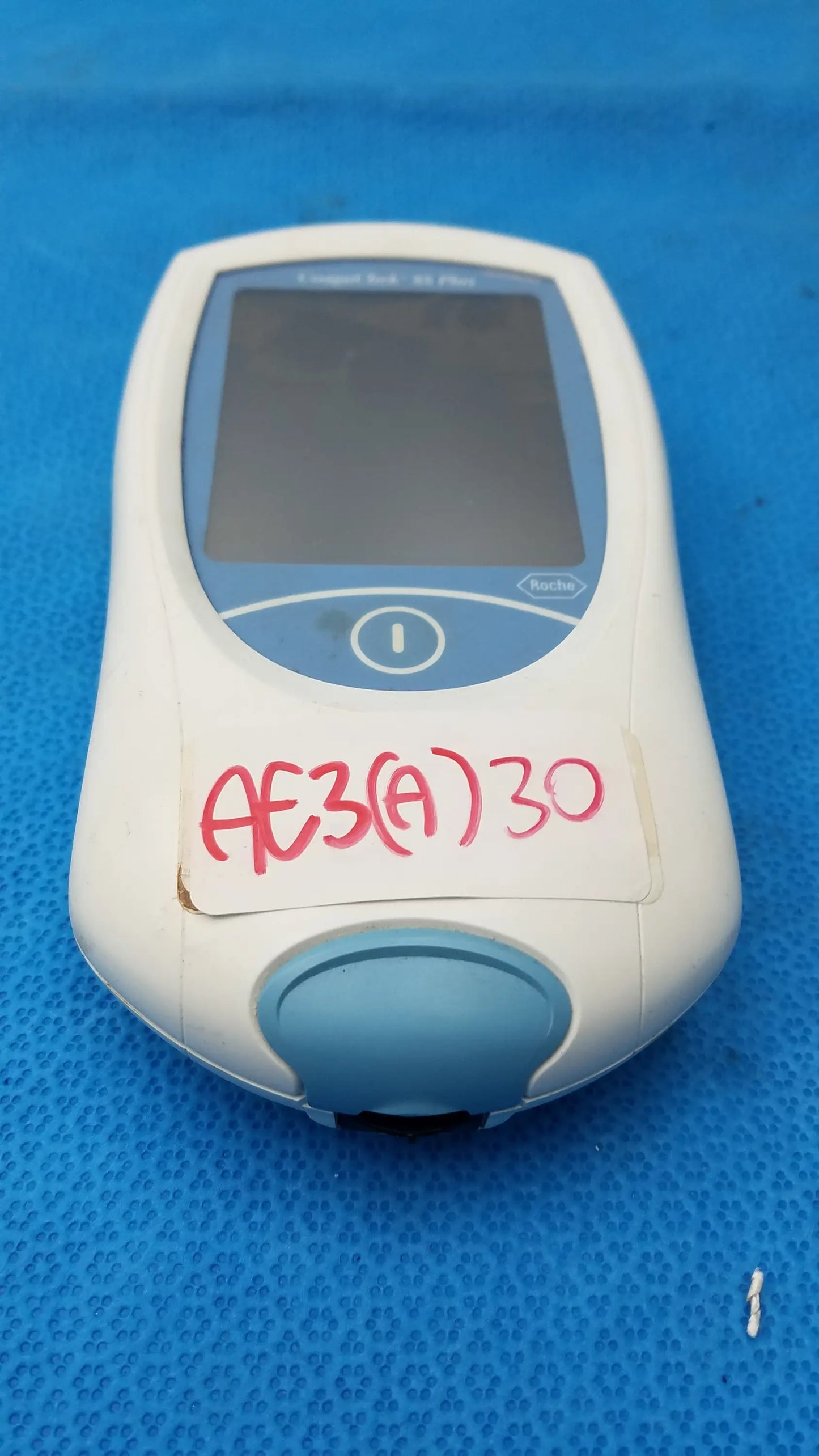 White and light blue roche coaguchek xs plus coagulation meter with small screen and circular button medical equipment