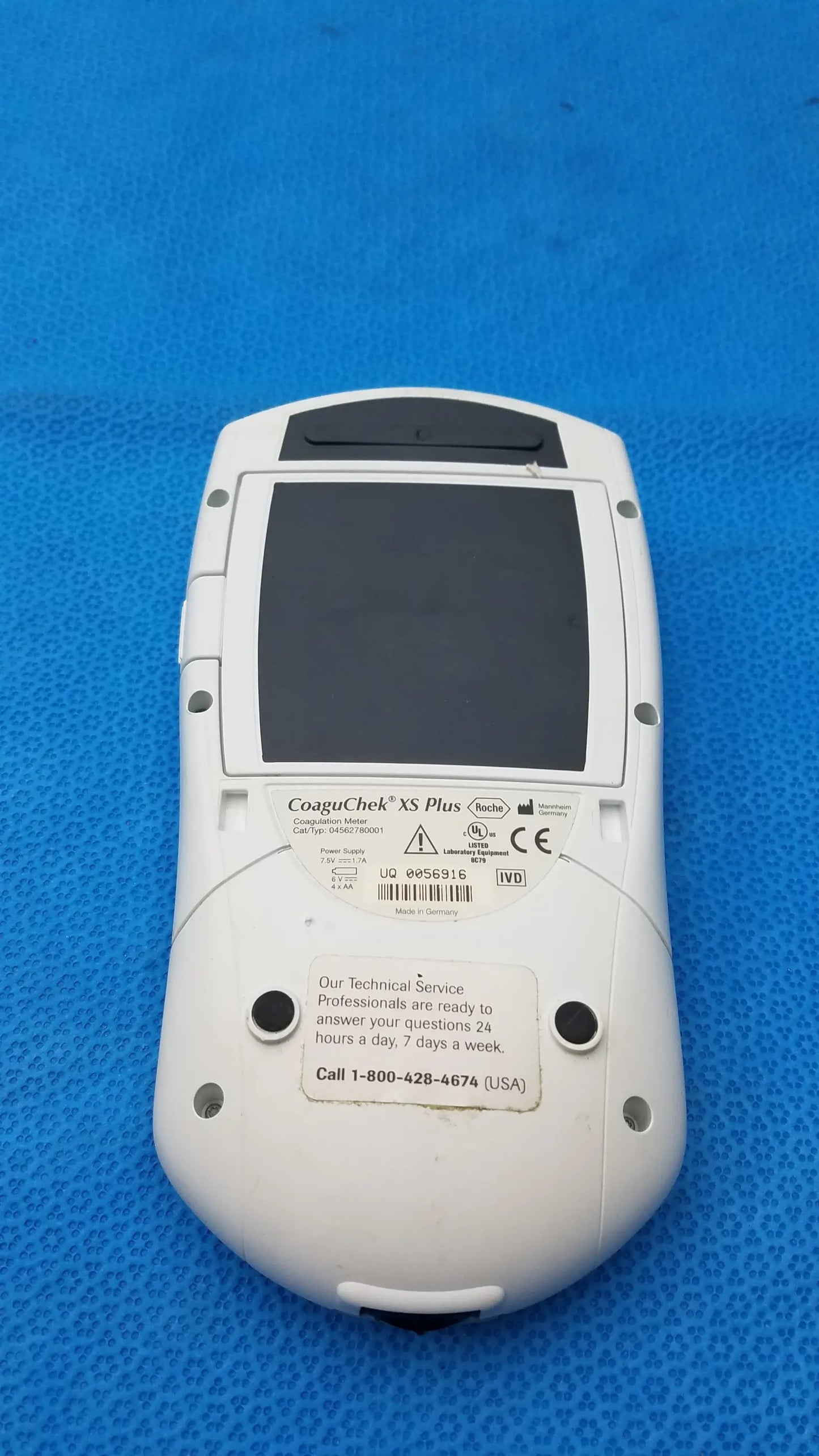 White plastic roche coaguchek xs plus coagulation meter with black screen and rounded edges medical equipment