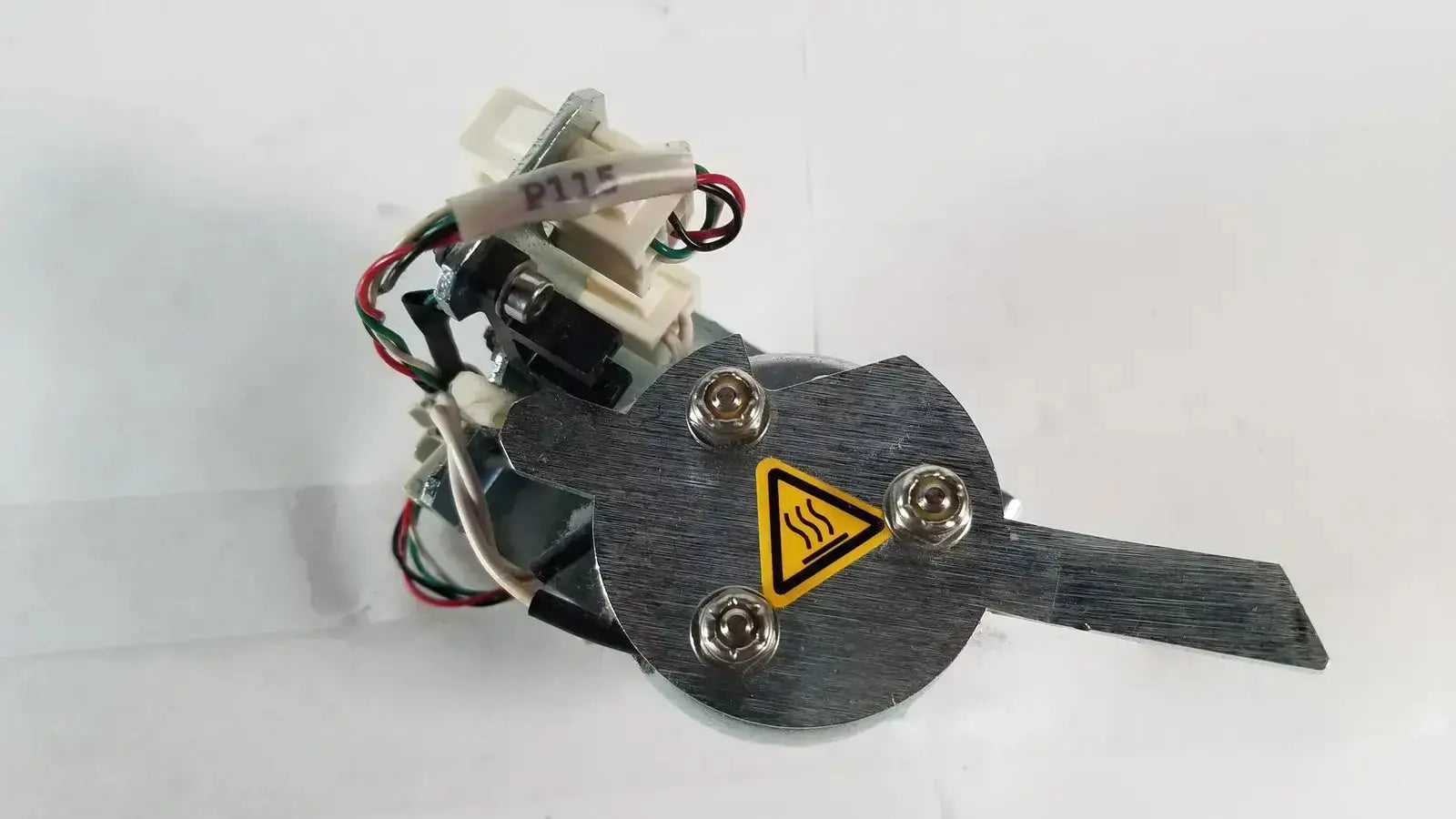 Black metal heat exchanger with yellow warning label and four silver bolts for saia burgess ledex products hospital surplus