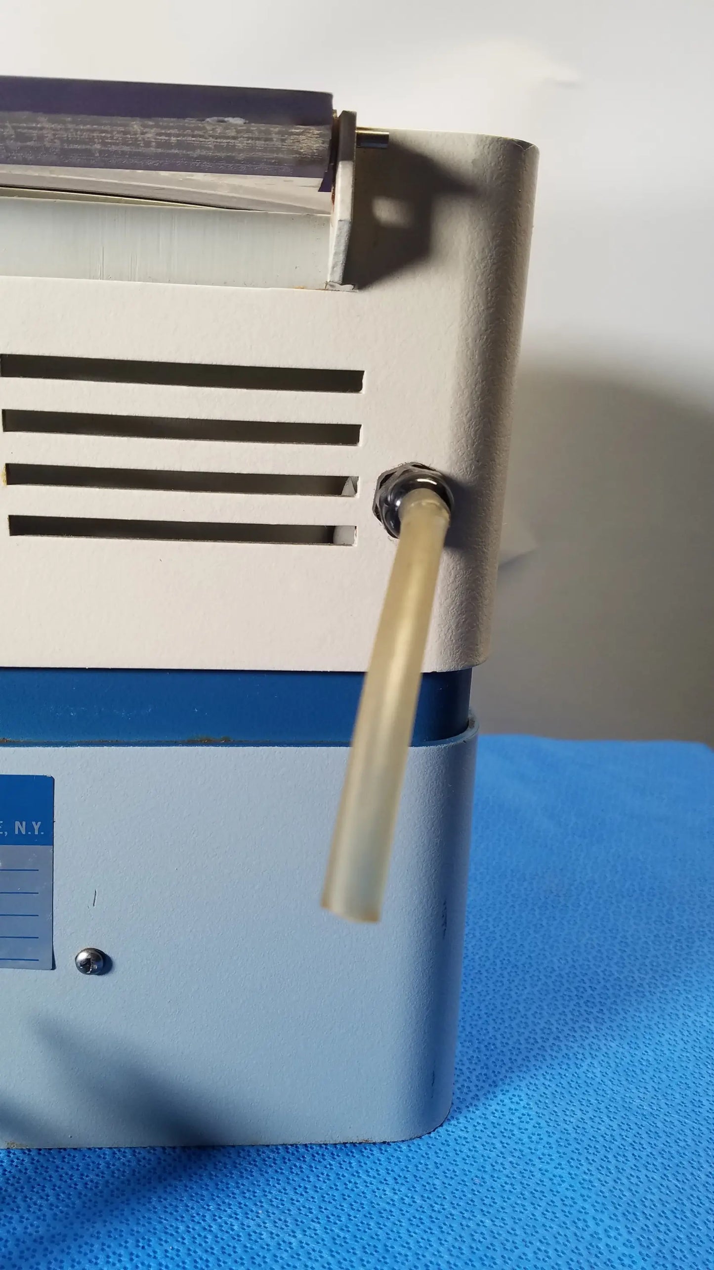 A beige plastic tube extends from a metallic fitting on the side of the savant HSC 10K-115 high speed centrifuge medical equipment