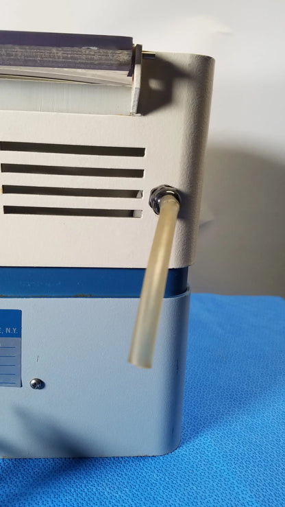 A beige plastic tube extends from a metallic fitting on the side of the savant HSC 10K-115 high speed centrifuge medical equipment