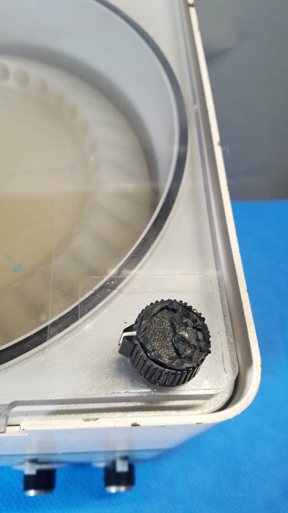 Black textured knob with ridged edge and metallic clasp on the savant hsc 10k-115 high speed centrifuge medical equipment