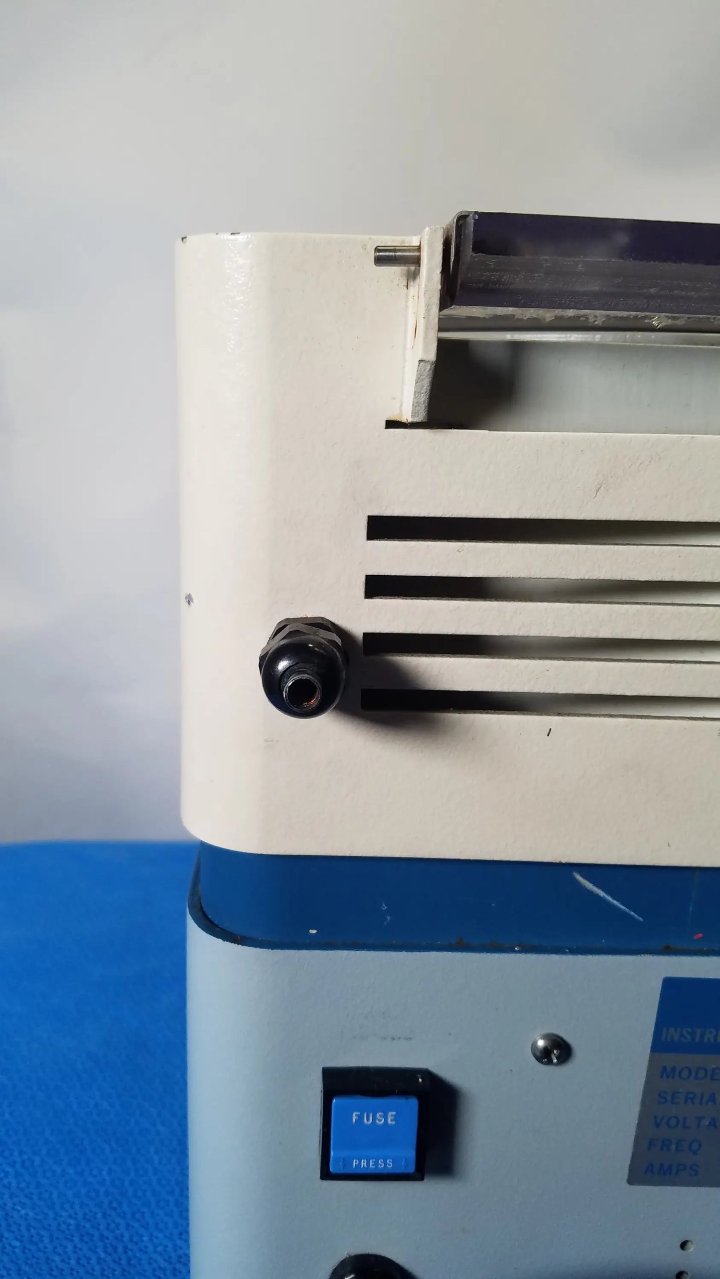 White and blue savant hsc 10k-115 high speed centrifuge showing black fuse button and ventilation slats for medical equipment reuse