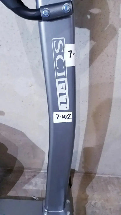 Gray metal frame of a schift brand upright exercise bike with black handlebars and white branding stickers