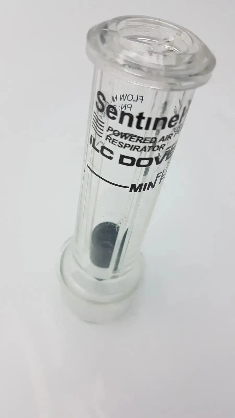 Clear plastic sentinel xl ilc dover min flow meter canister with black internal component and white labeling for respiratory use