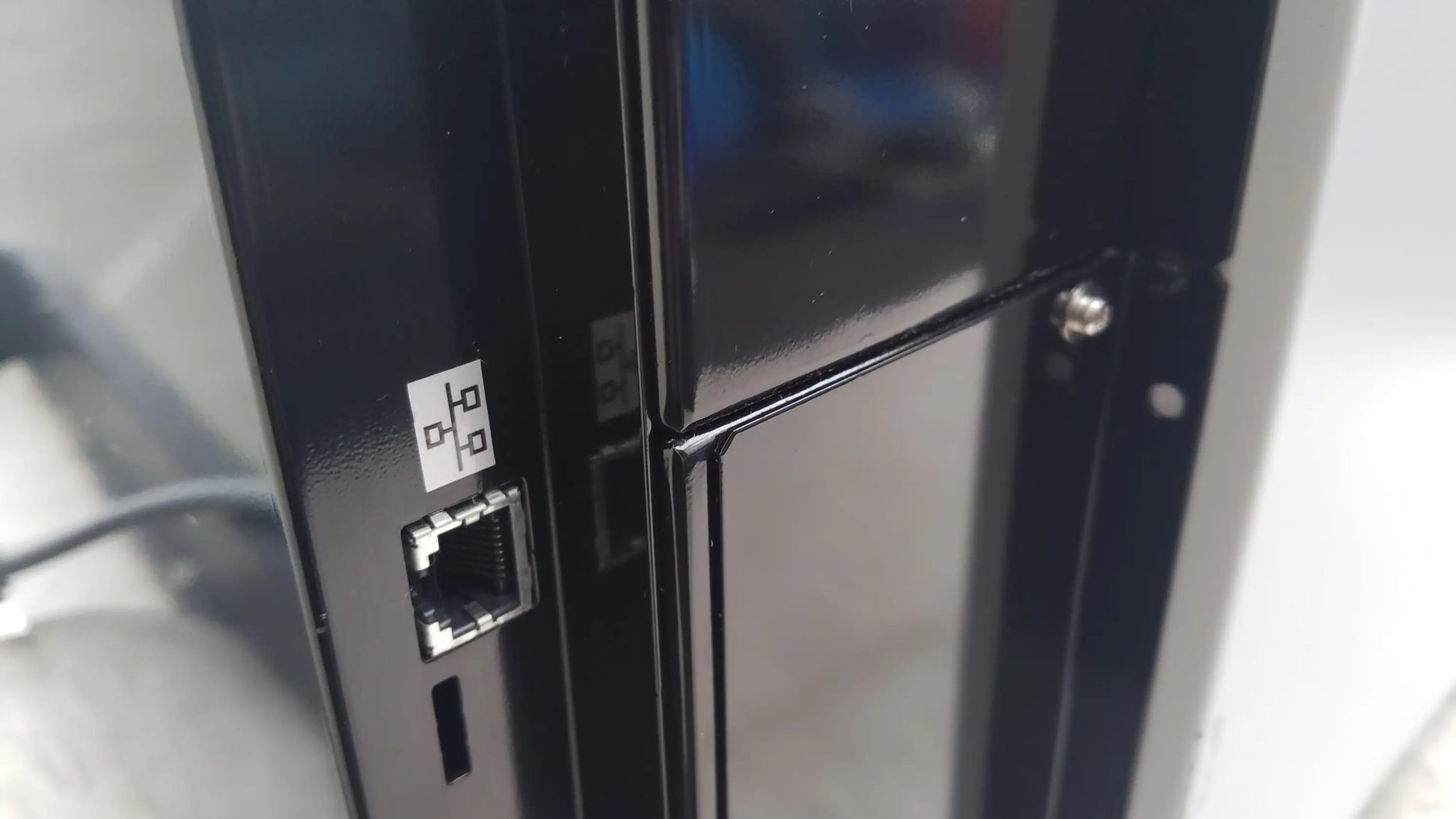 Black plastic ethernet port with white label on back side of shimadzu mce-202 multina microchip electrophoresis medical equipment