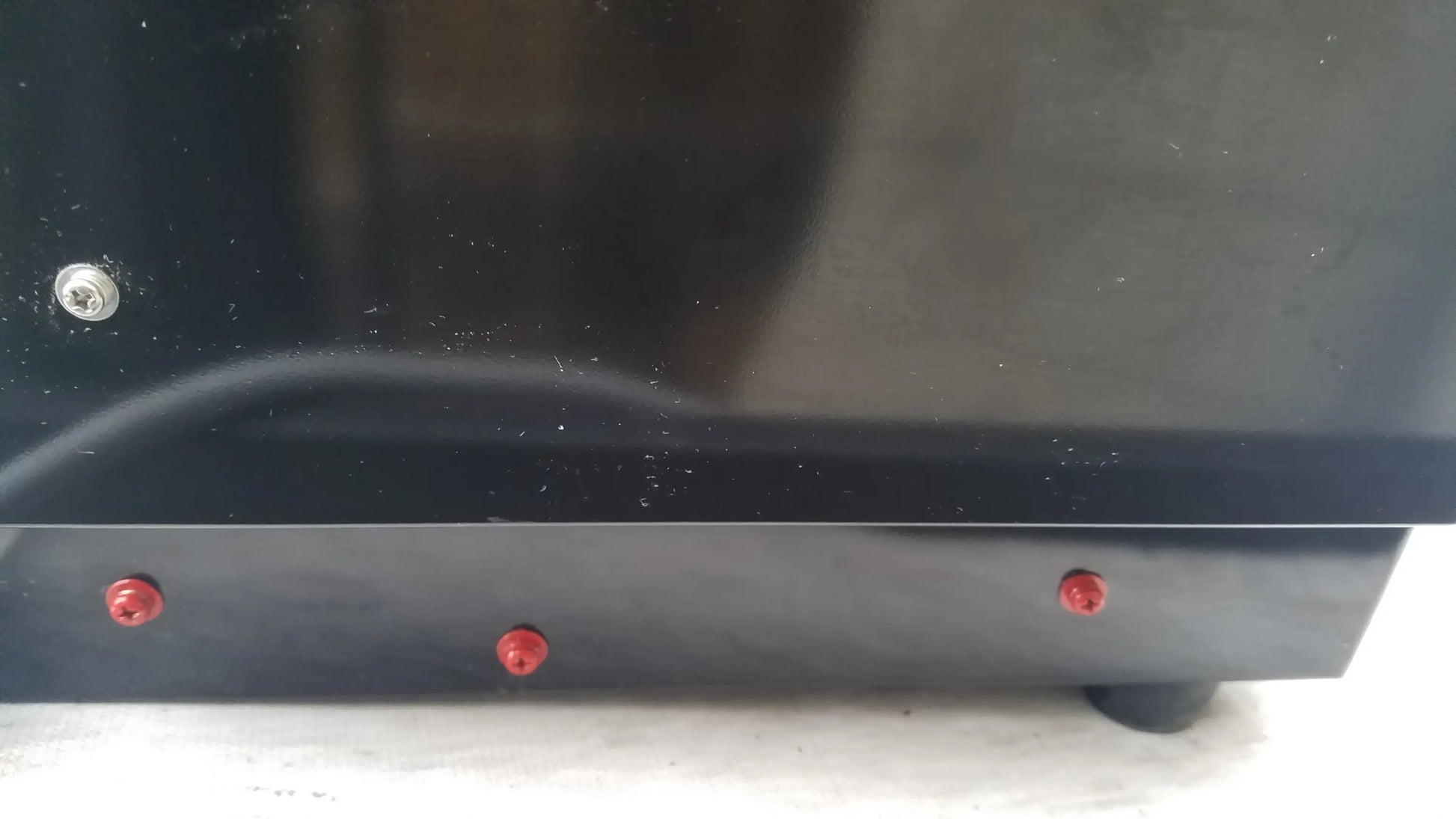 Black glossy base of shimadzu mce-202 multina microchip electrophoresis medical equipment with red and silver screws