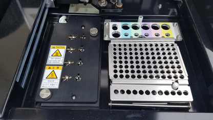The Shimadzu MCE-202 MultiNA microchip electrophoresis system features a metallic tray with circular holes and a colorful gradient, used in medical equipment