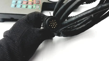 Black multi-cable connector with circular 24-pin interface held by gloved hand for siemens cincinnati milacron cnc lathe teach pendant controller