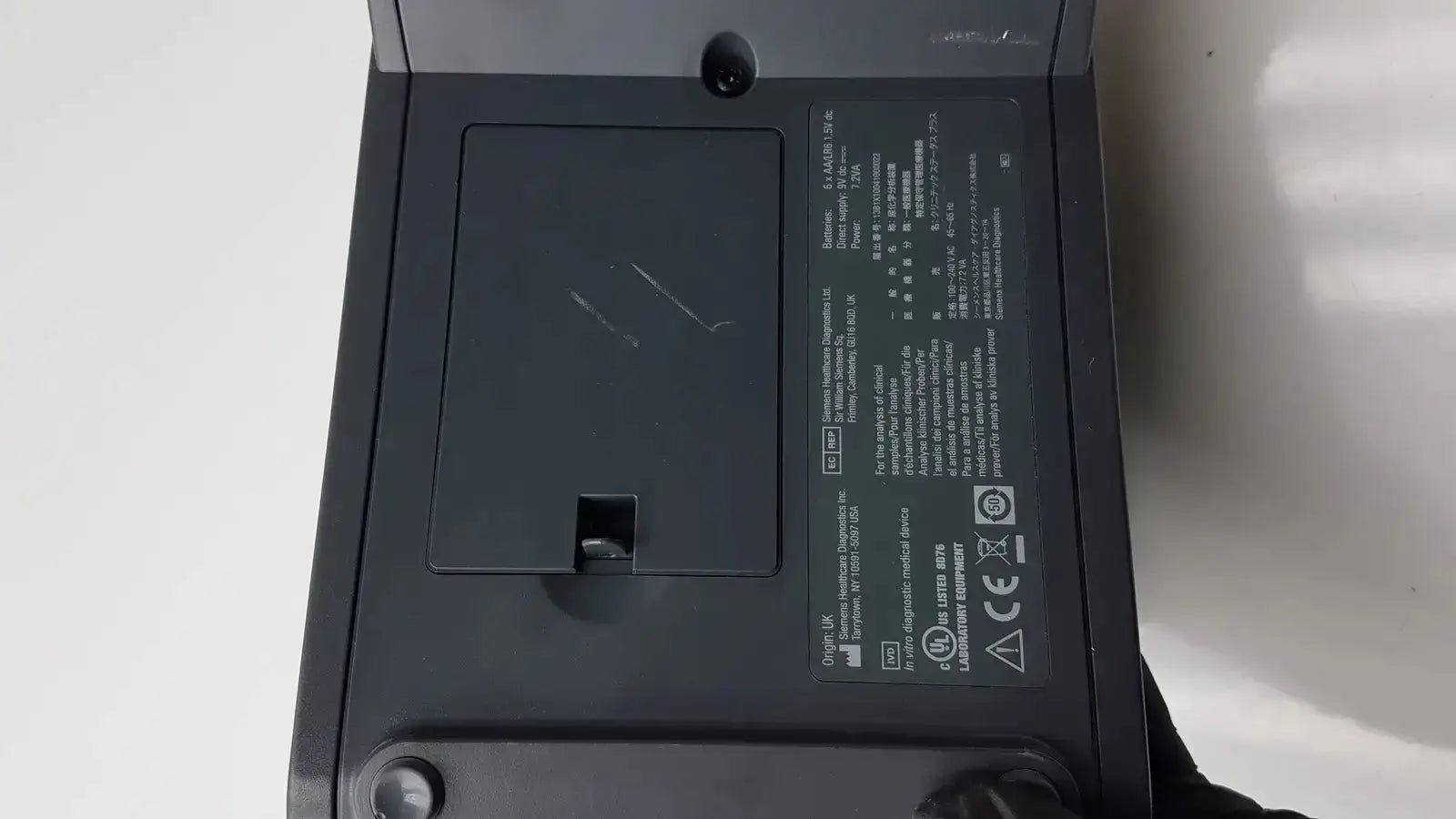 Black plastic Siemens Clinitek Status analyzer back with rectangular label showing technical specifications and certifications