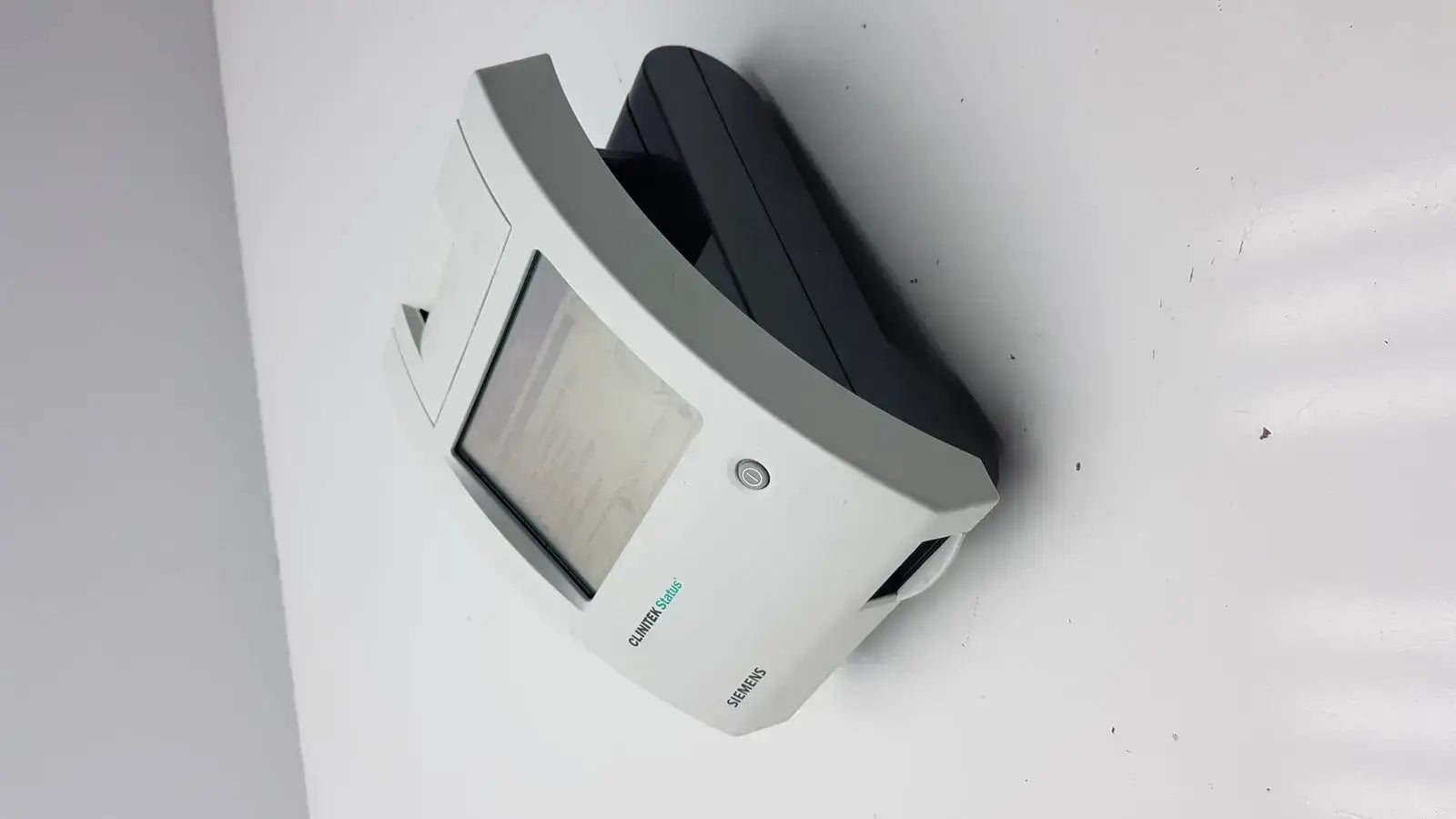 White and black Siemens motion sensor with rectangular display window on Siemens Clinitek Status Analyzer 004979 device