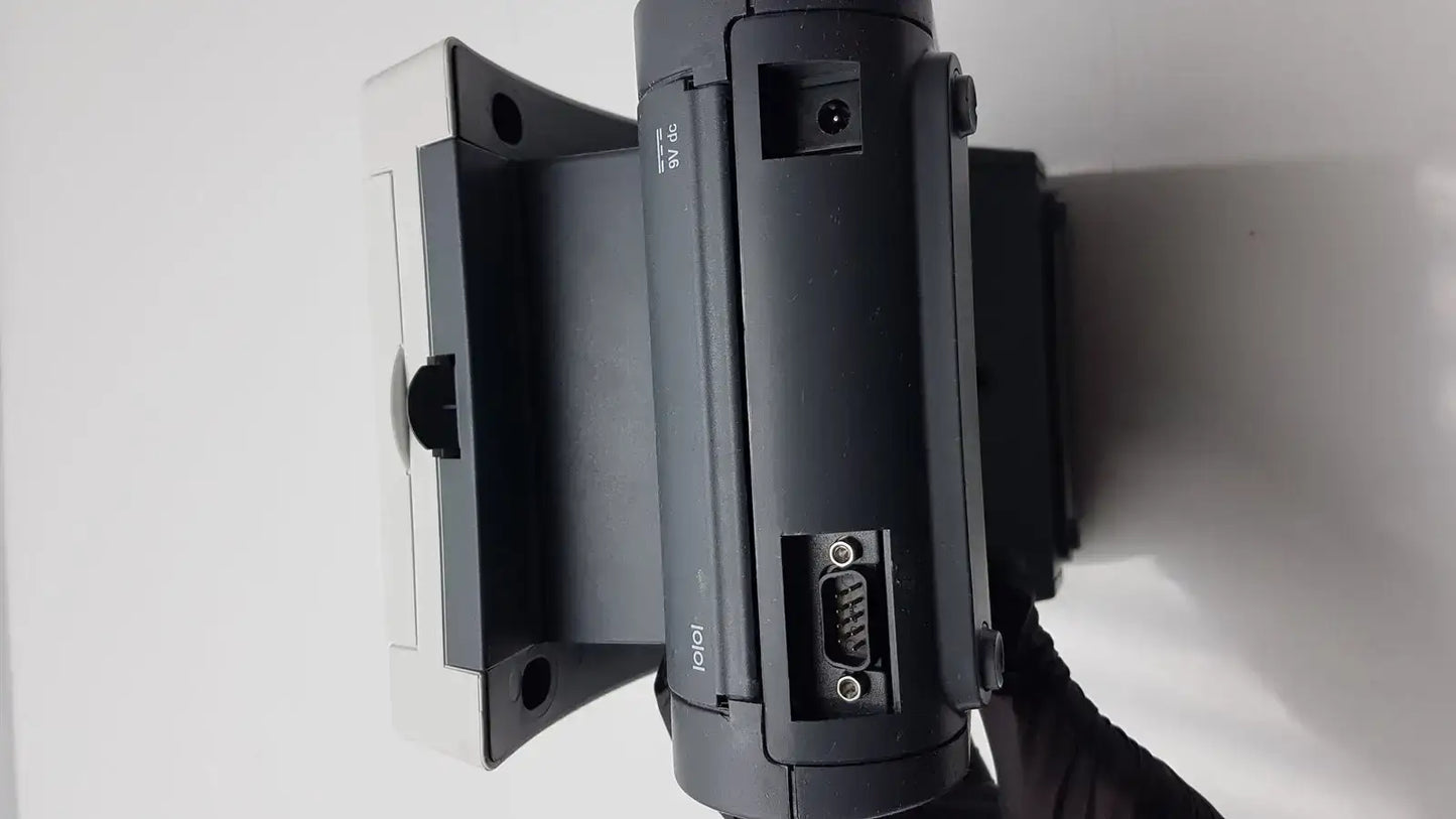 Black plastic siemens clinitek status analyzer with white mounting bracket and visible serial connector ports back view