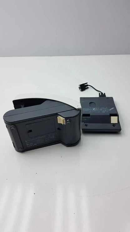 Black plastic nintendo switch dock with gold connectors and power cable attached showing back side for siemens clinitek status analyzer model 004979