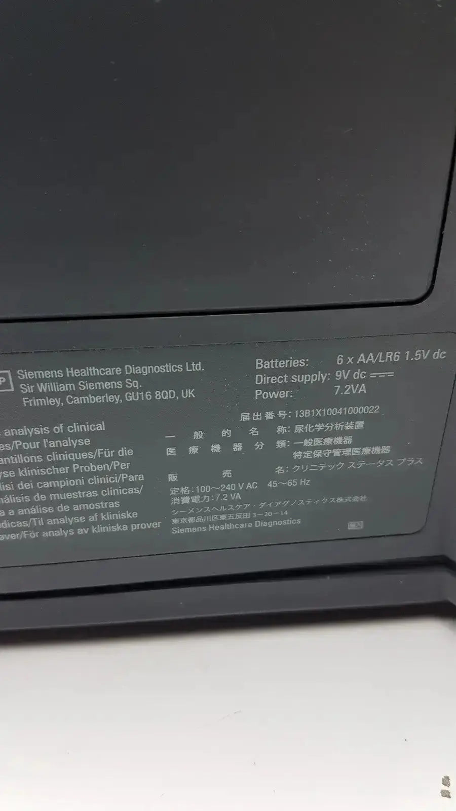 Black plastic label with white text showing technical specifications on the back of siemens clinitek status analyzer model 004979