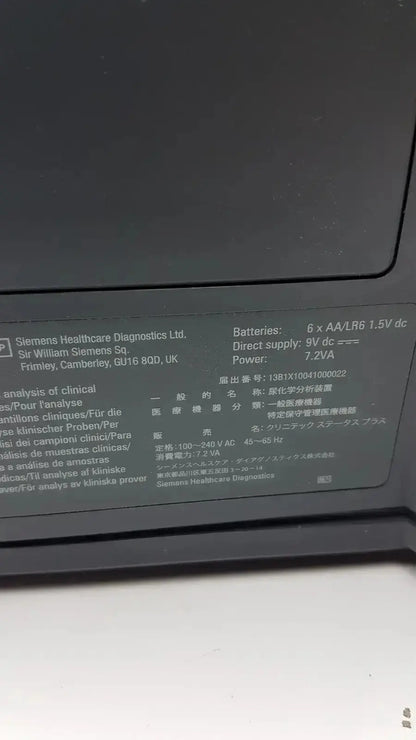 Black plastic label with white text showing technical specifications on the back of siemens clinitek status analyzer model 004979