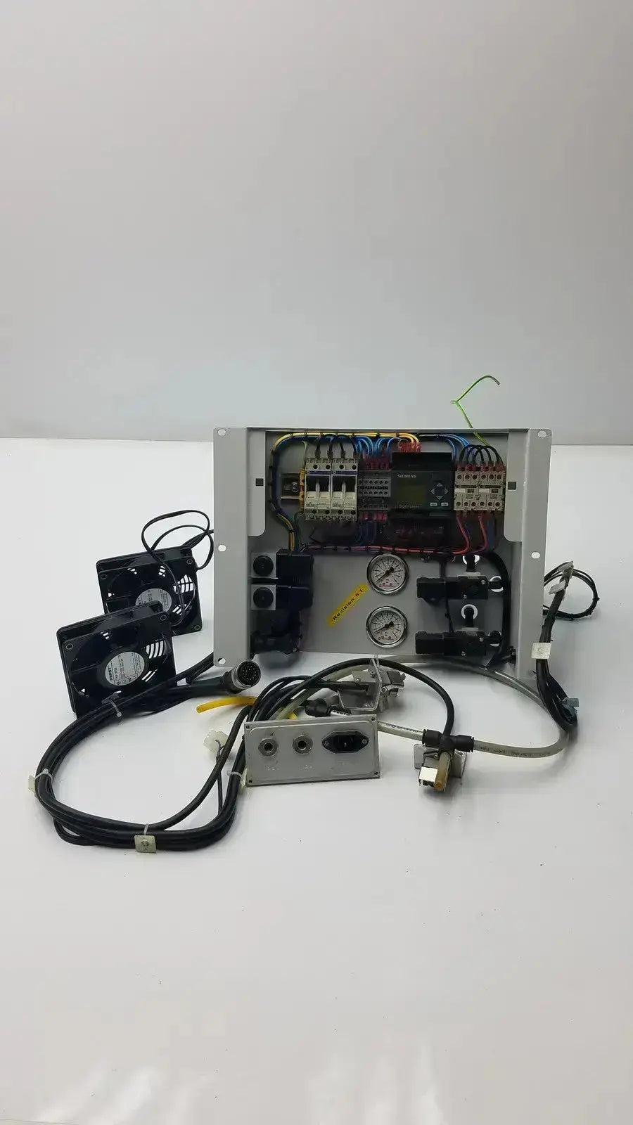 Industrial control panel with exposed wiring, gauges, and black fans in metallic Siemens LOGO 230rc 6ed1 052-1fb00-0ba4 housing