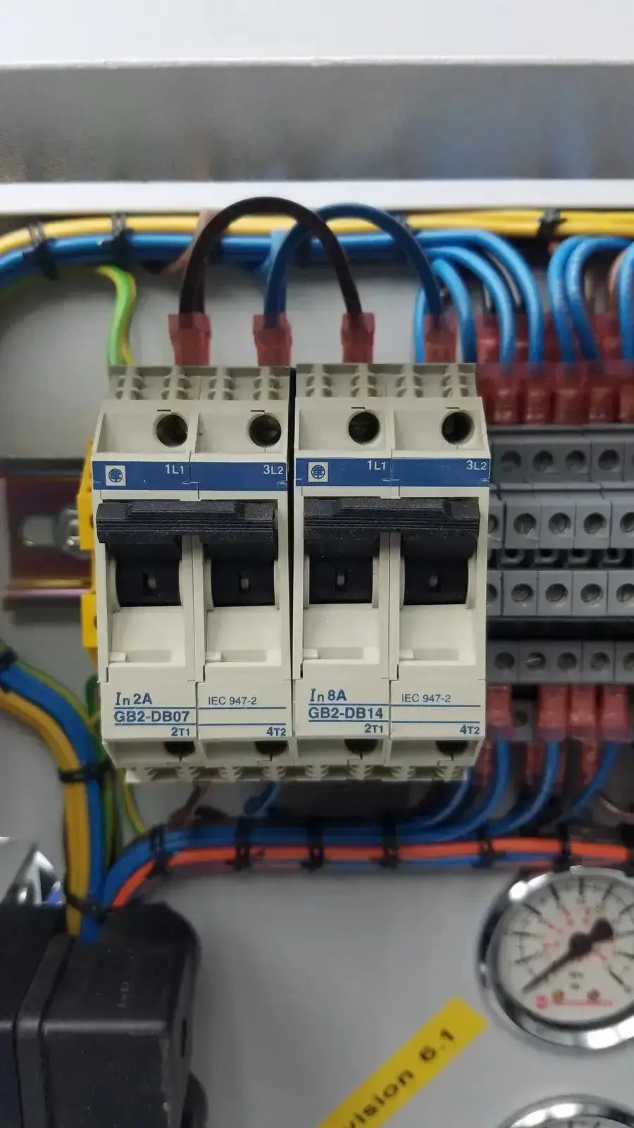 Two beige and blue siemens 230rc 6ed1 052-1fb00-0ba4 circuit breakers with black handles in an electrical panel