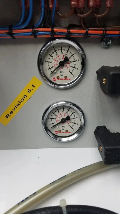 Two circular chrome-framed pressure gauges with white faces and red markings on siemens logo 230rc 6ed1 052-1fb00-0ba4 panel