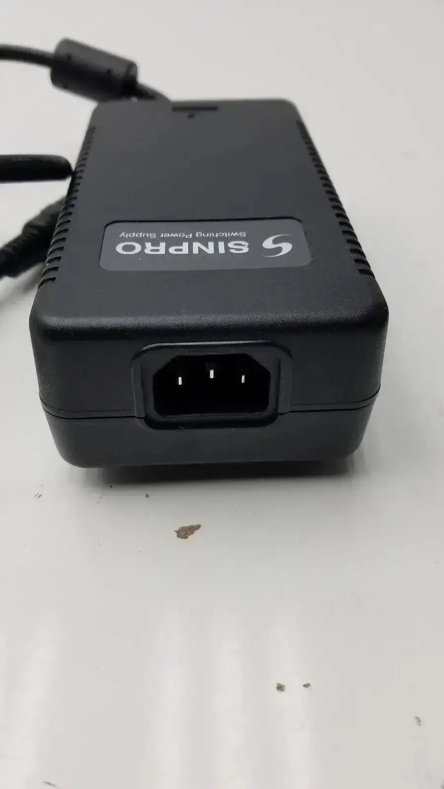Black plastic sinpro switching power supply adapter with ventilation slots and power cable for pre owned medical equipment g-bbde3-17k