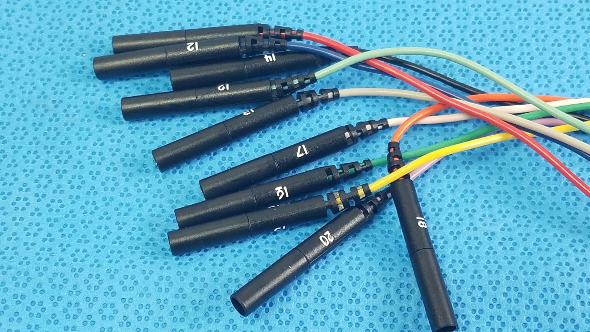 Black ignition coils with numbered markings and colorful wiring on the back side of sjm st jude medical diagnostic connection cable for reuse medical equipment