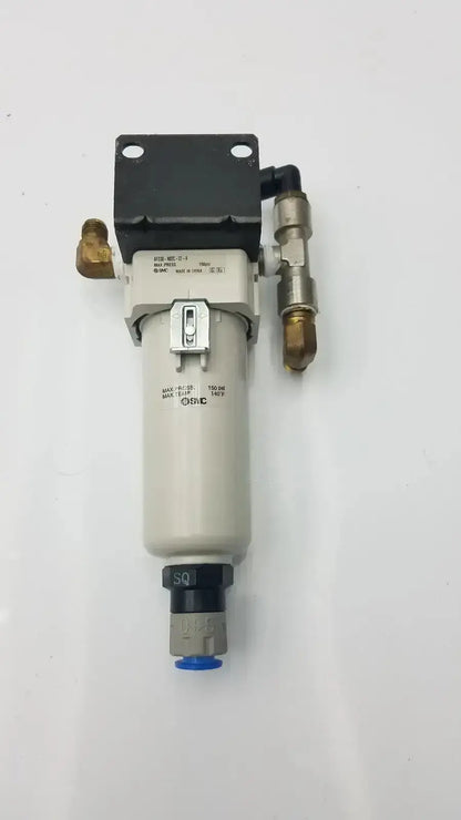 Gray cylindrical smc fd30-n02c-2z-a air filter with black top plate brass fittings and silver toggle switch rated for 150 psi max pressure