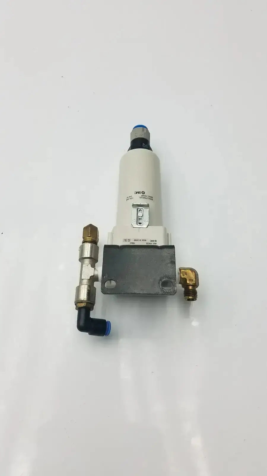 Smc fd30-n02c-2z-a white cylindrical air filter with brass fittings and blue cap rated for 150 psi max pressure mounted on gray base