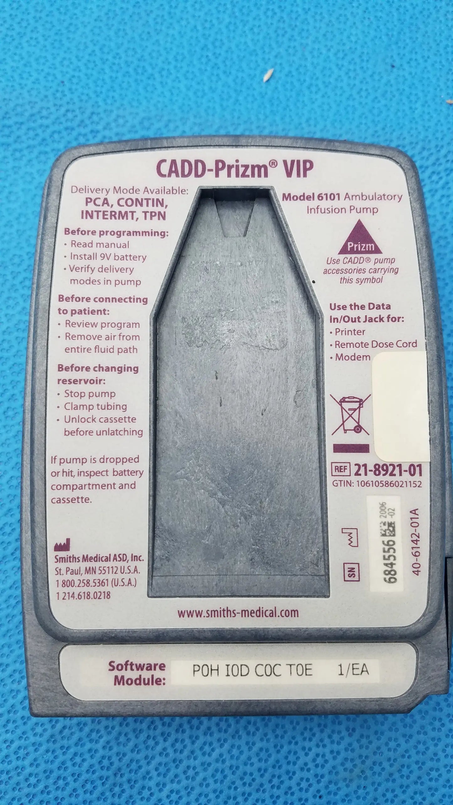 Gray plastic Smiths Medical 6100 Cadd Prizm ambulatory infusion pump with textured surface and printed instructional labels