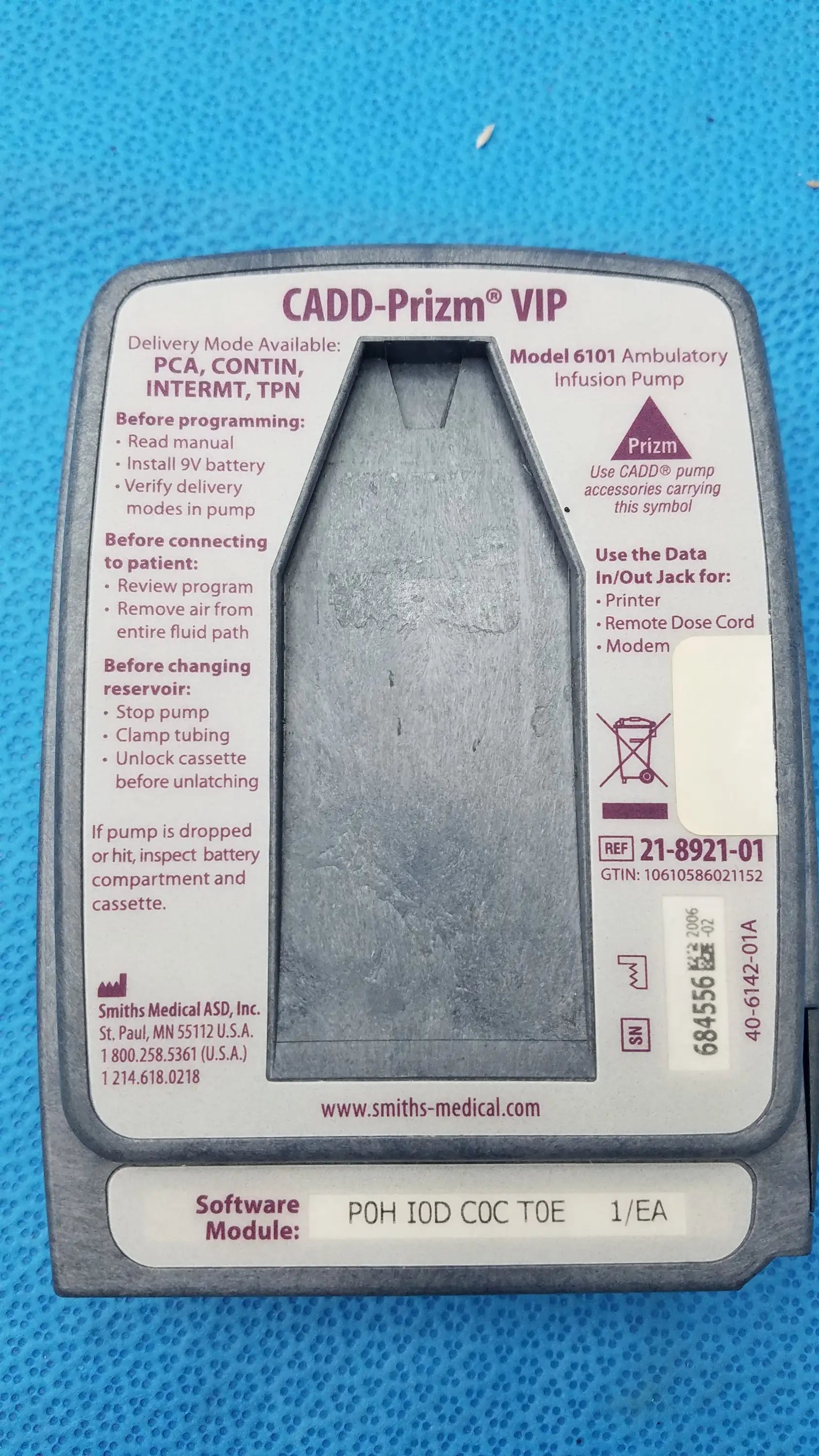 Gray plastic Smiths Medical 6100 Cadd Prizm ambulatory infusion pump with textured surface and printed instructional labels